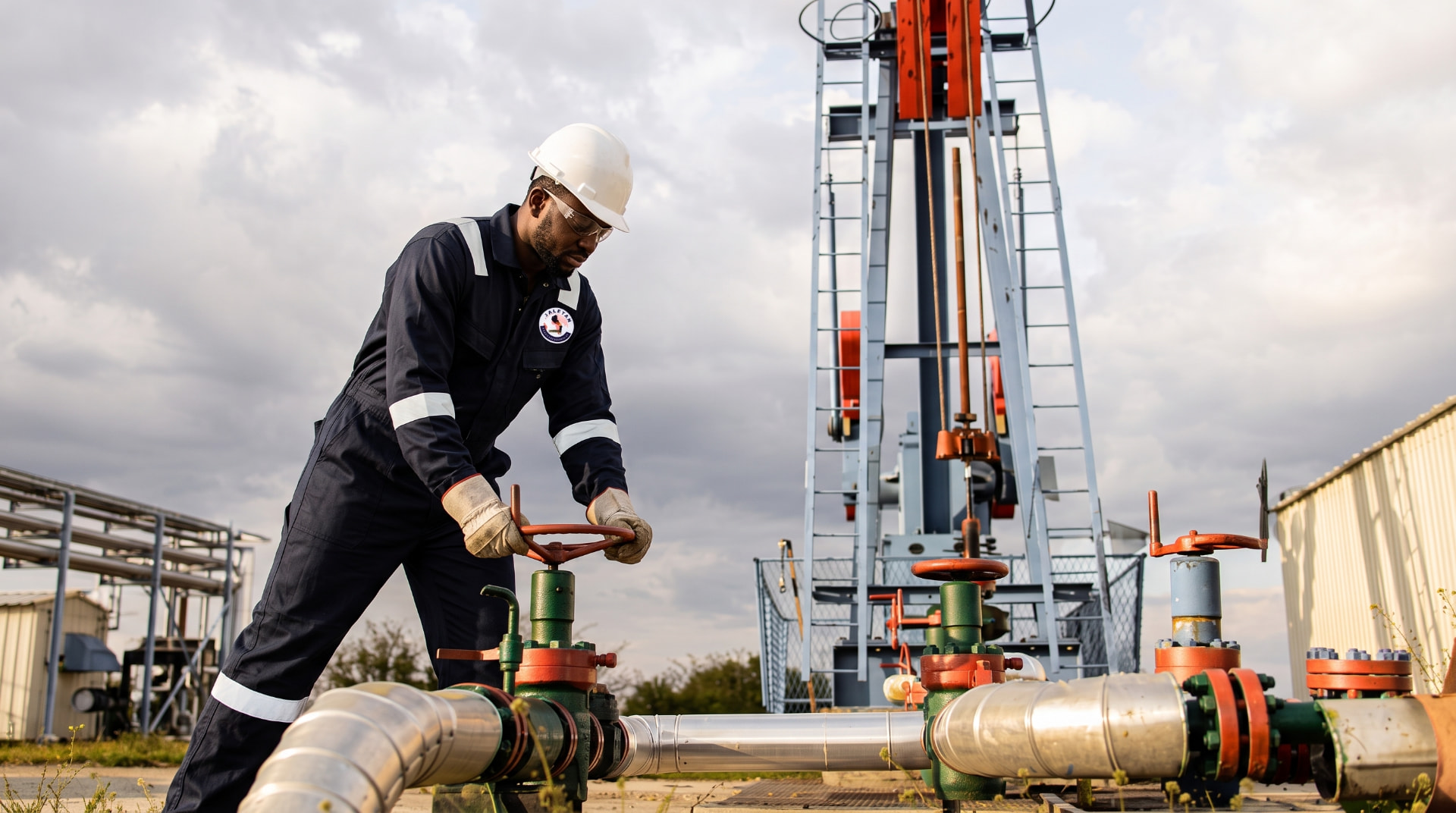 Technician operating a valve on oilfield process piping
