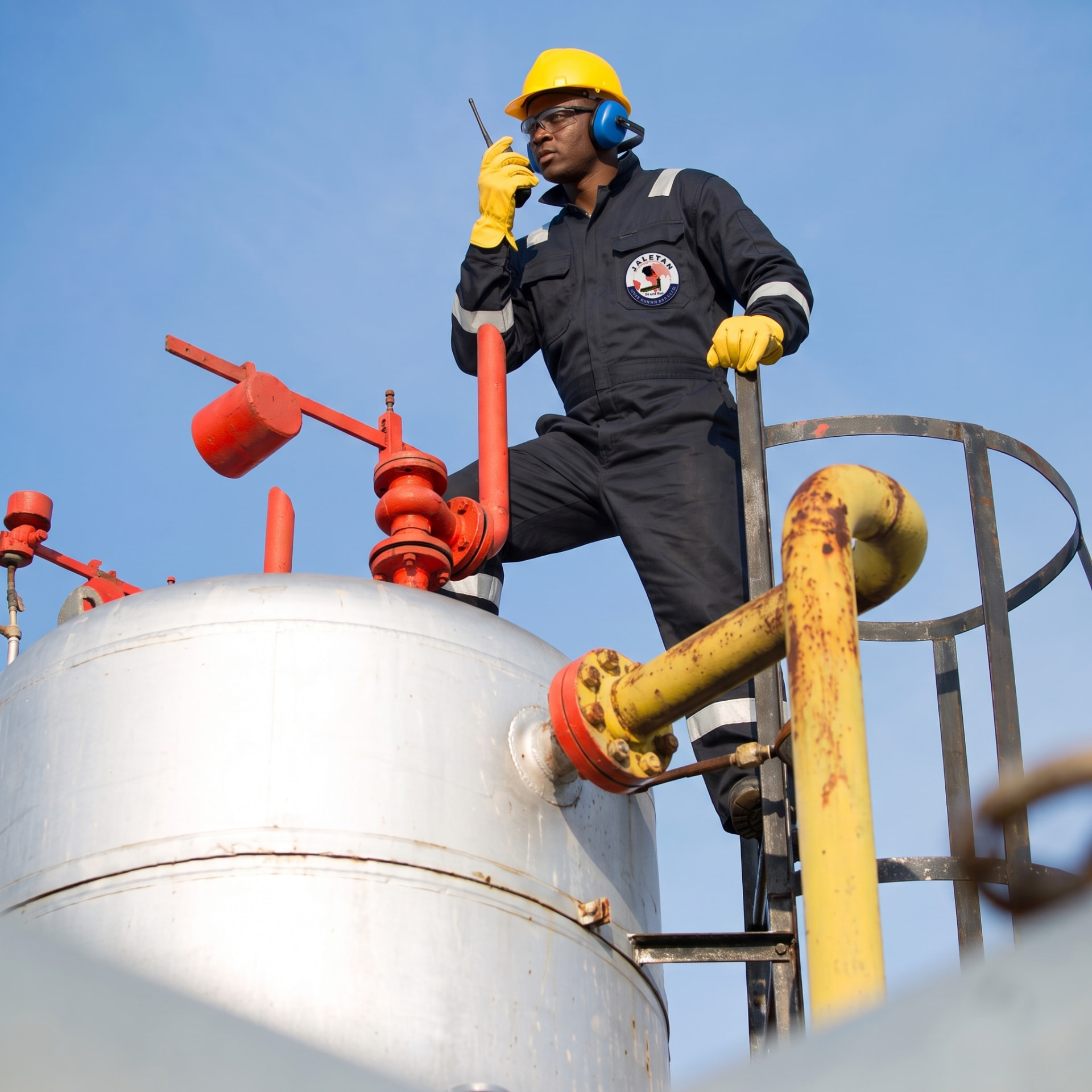 Jaletan technician coordinating field operations atop a storage tank