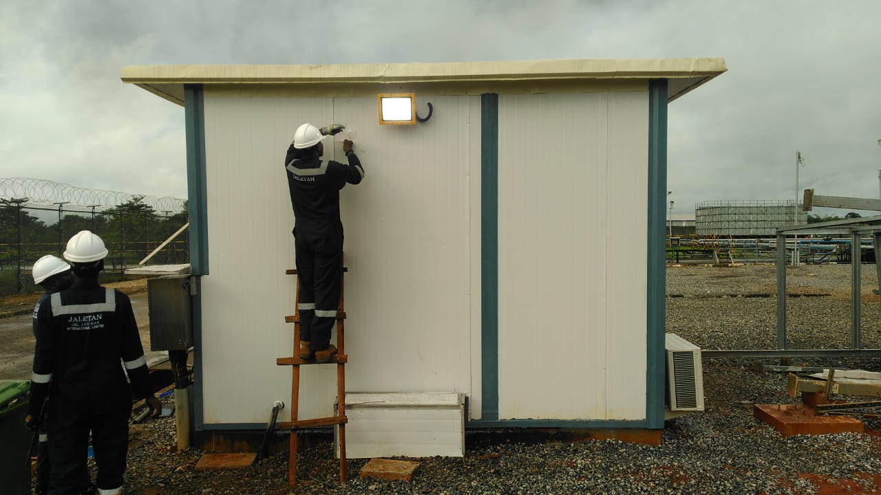 Jaletan workers performing maintenance on a portable industrial cabin